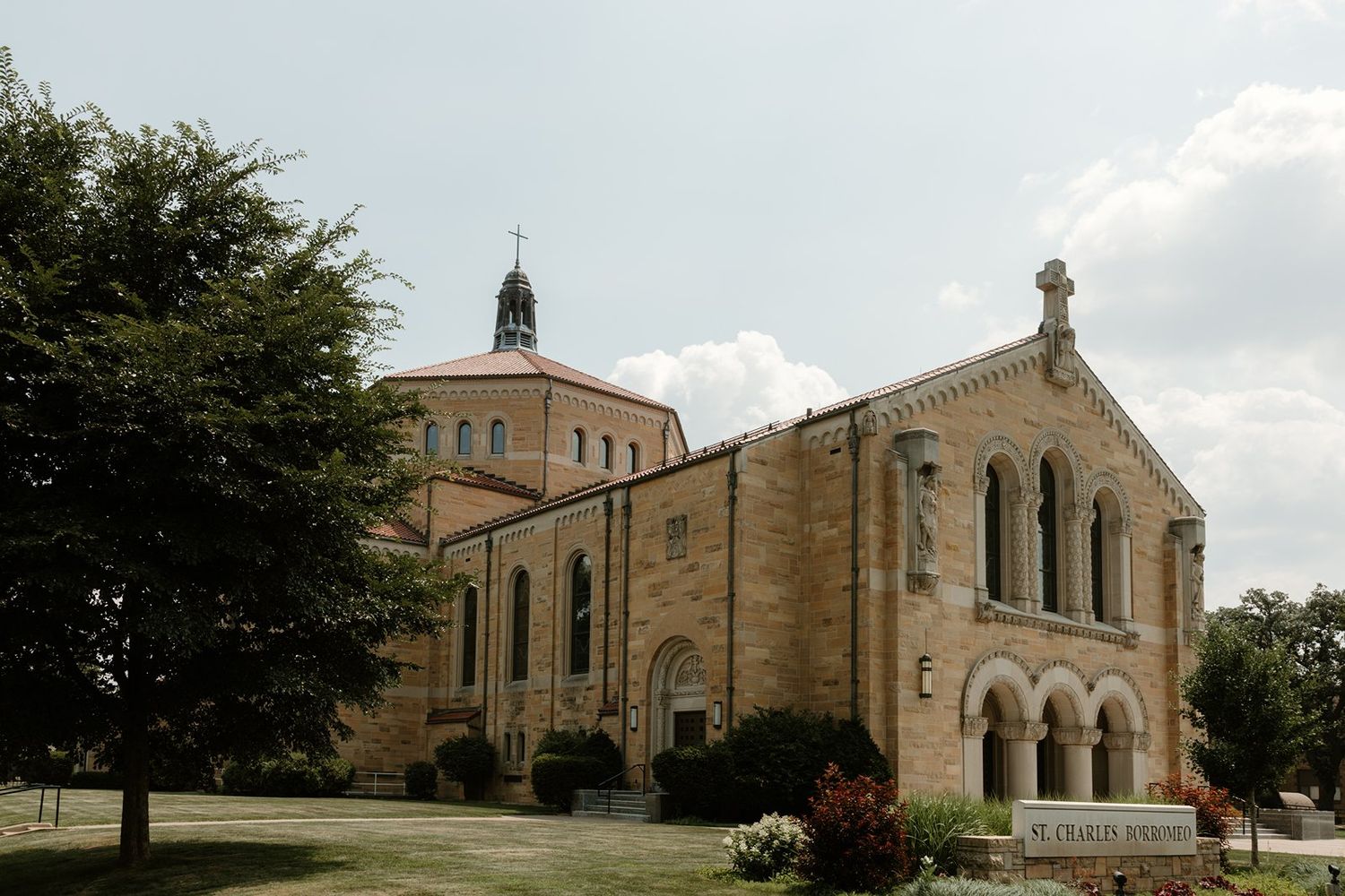 Stone church buildings with arched windows and architectural details form part of a religious campus complex.
