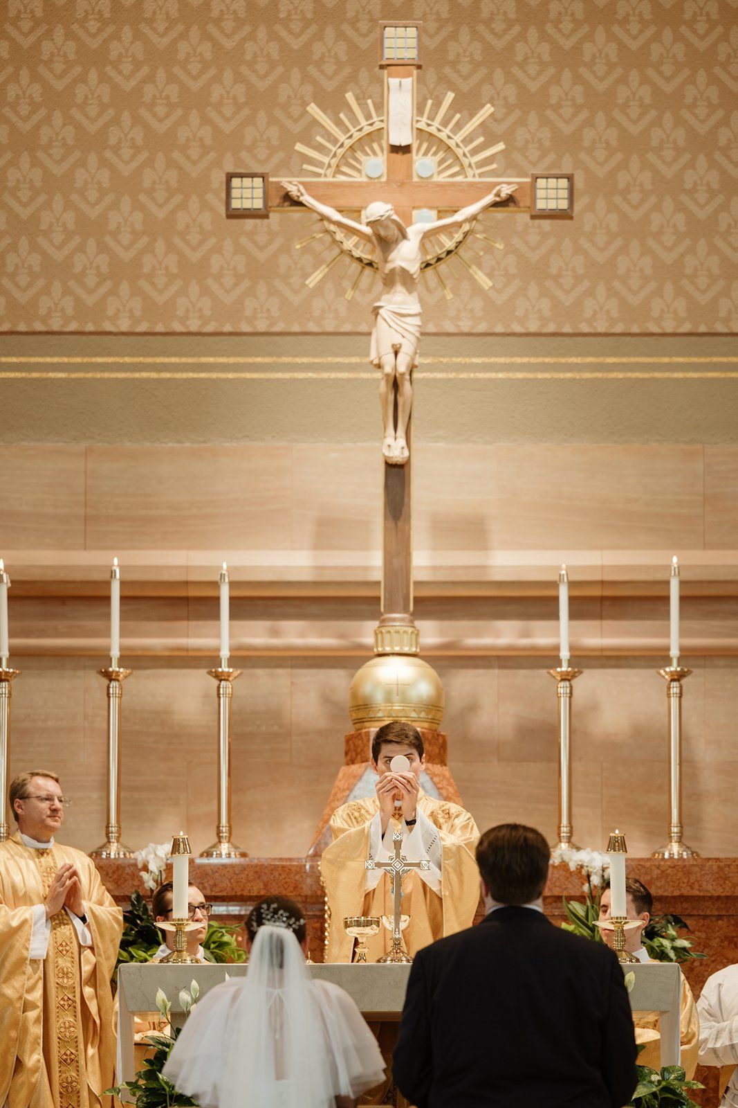 A traditional Catholic church altar decorated with candles and crucifix during a religious ceremony.