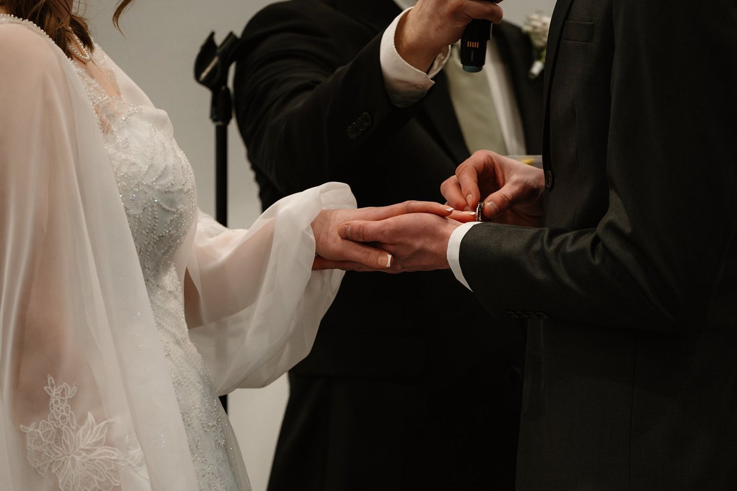 Close-up shot of wedding rings being exchanged during a marriage ceremony.