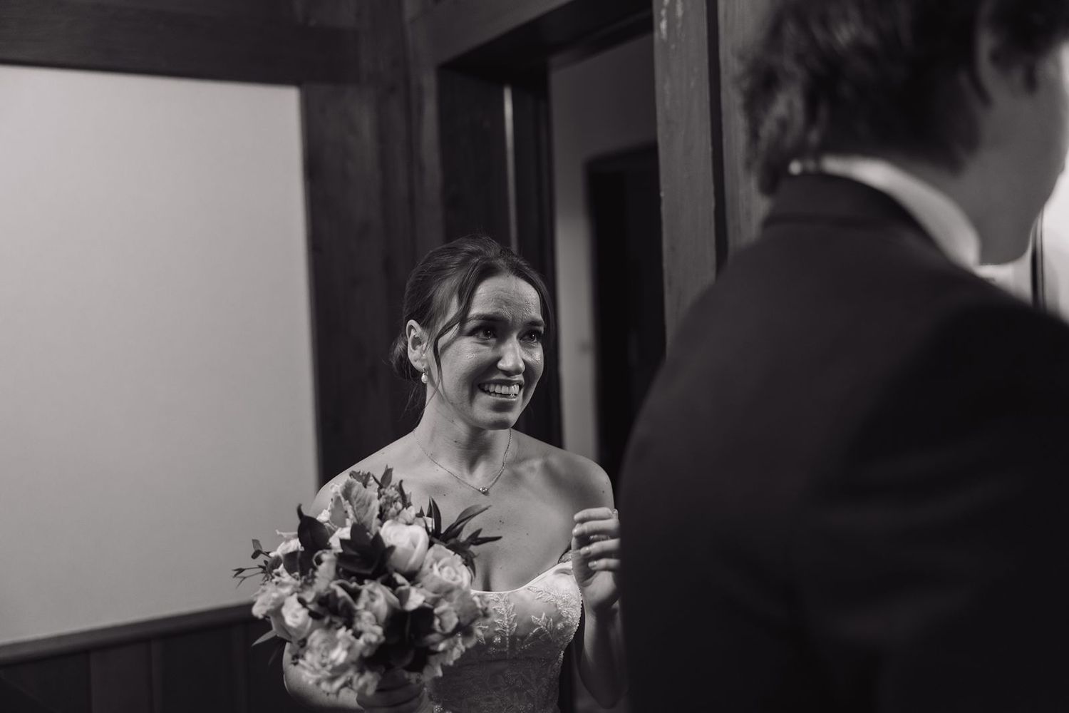 A bride in a strapless gown holds a bouquet during her wedding ceremony.