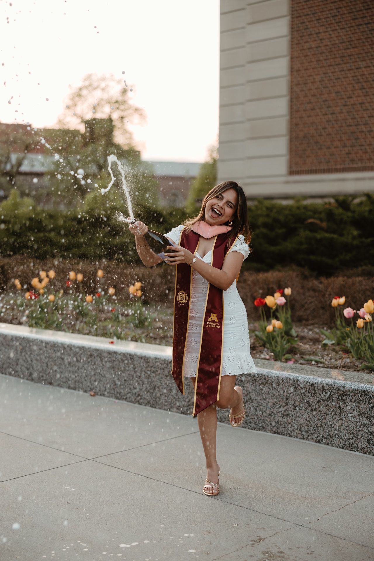 Girl popping champagne for a minneapolis graduation photographer
