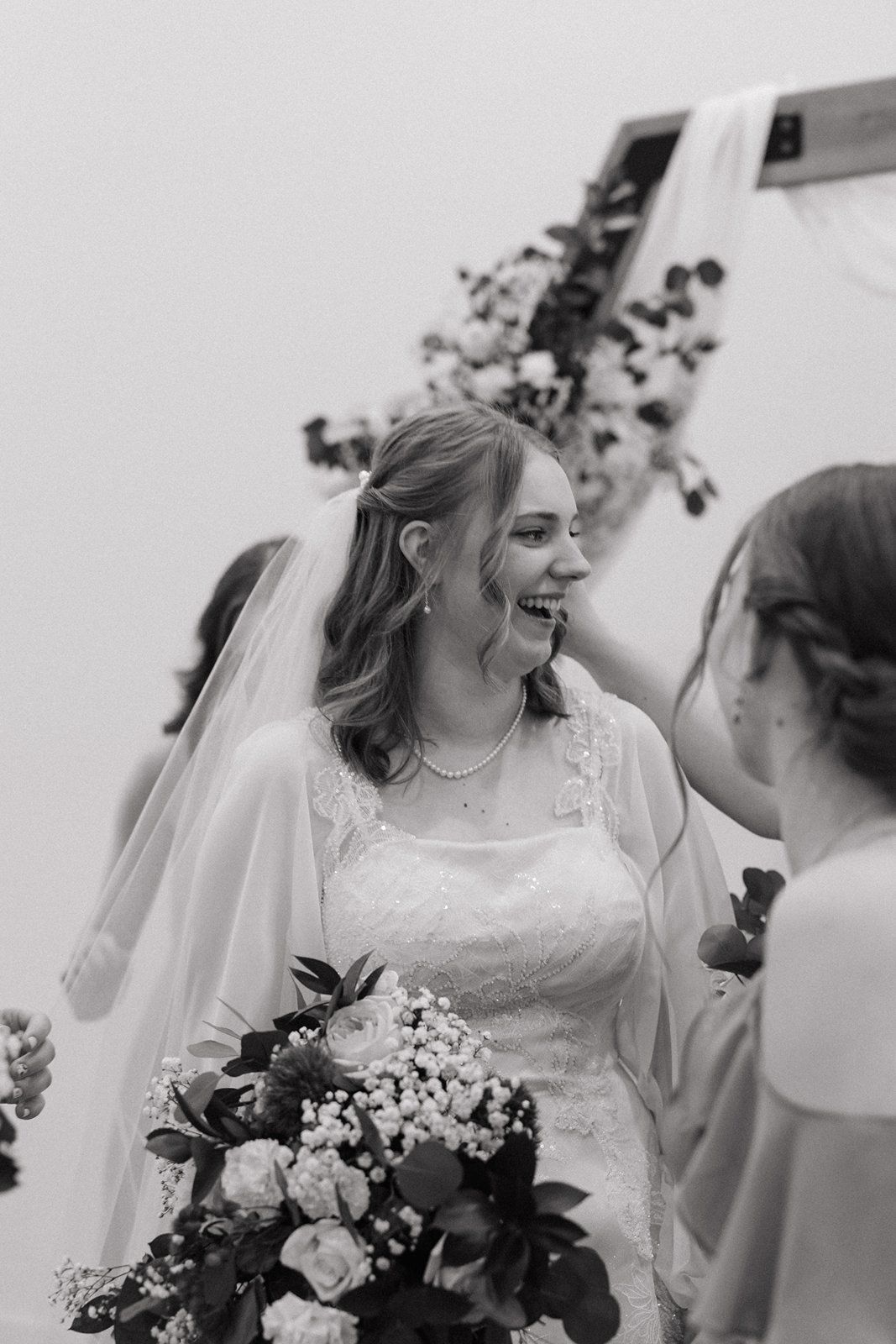 A candid series of black and white photos showing joyful moments at a wedding with a bride holding white flowers.