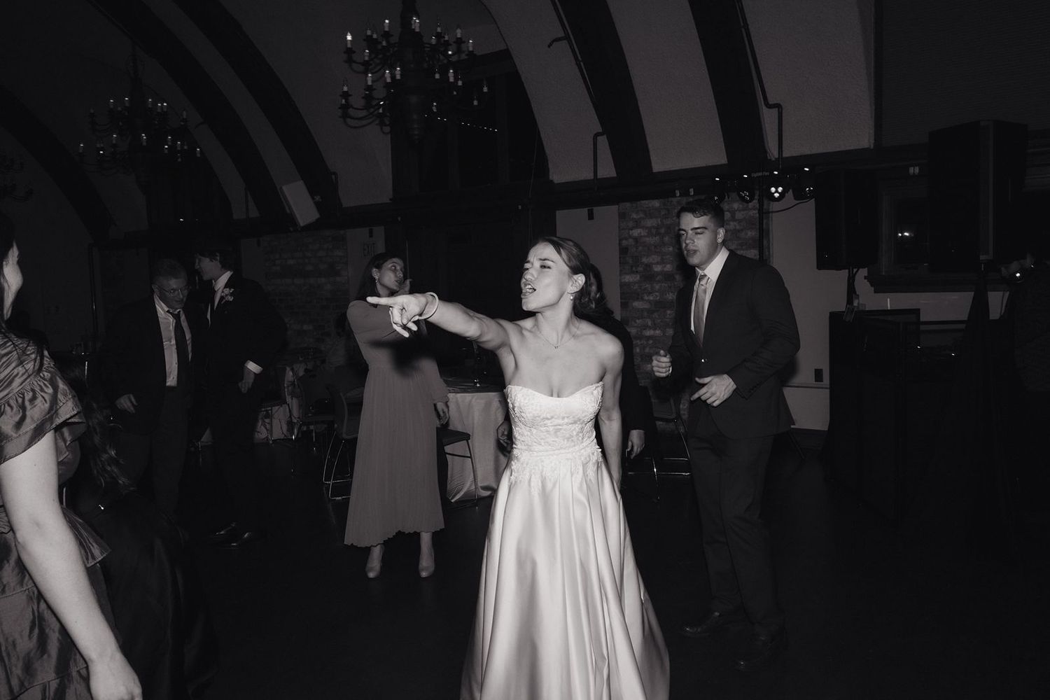 A vintage-style black and white photo of dancing at a wedding reception.