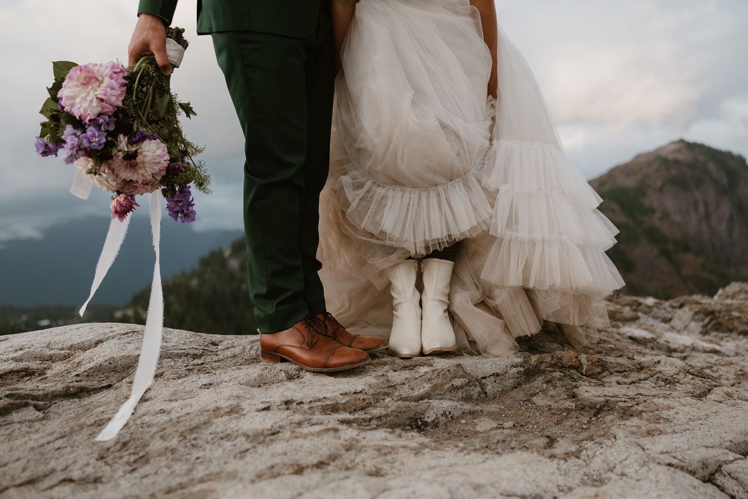 Bride shows off cowgirl boots during adventure elopement photography session