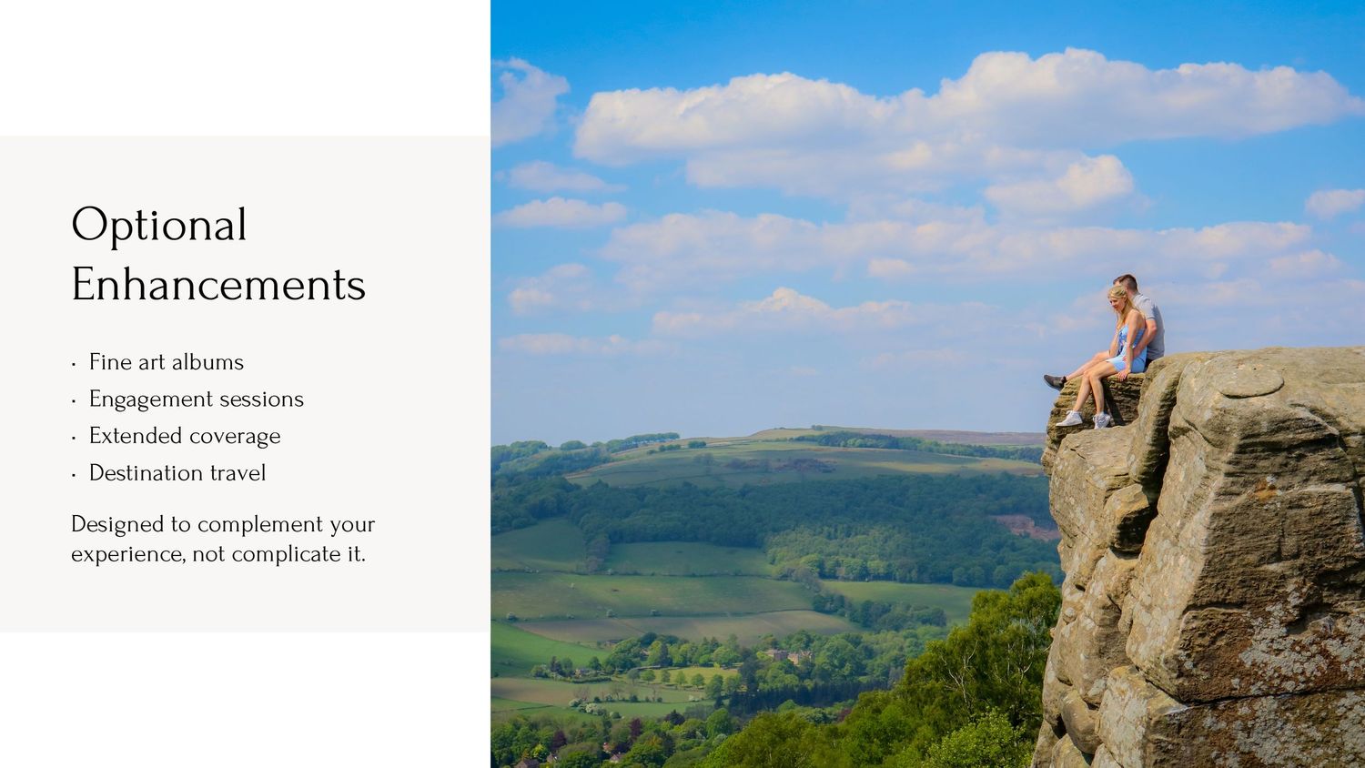 Person sits on edge of dramatic cliff overlook with sweeping green valley and rolling hills stretching to horizon.