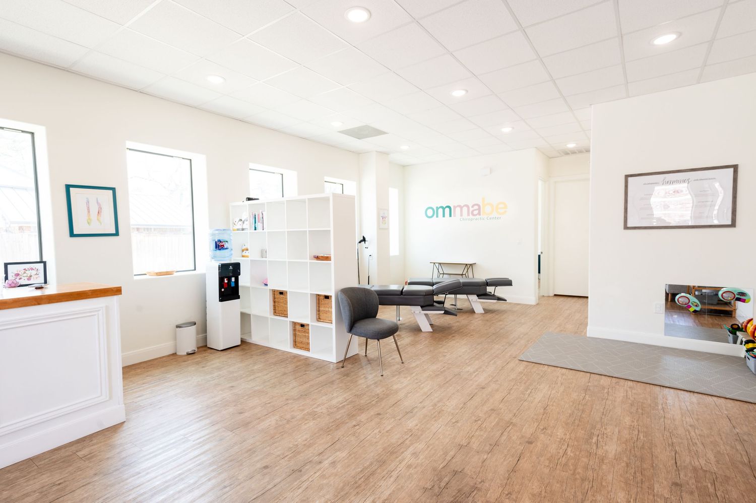 Modern medical office interior with hardwood floors, white walls, and reception area.