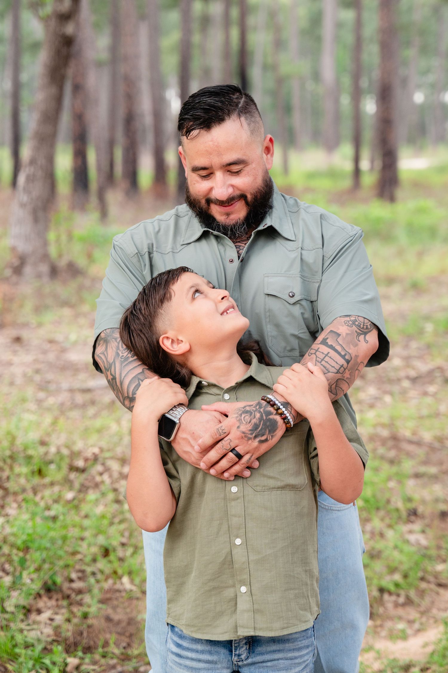 Heartwarming moment between two people sharing laughter in a pine forest setting.