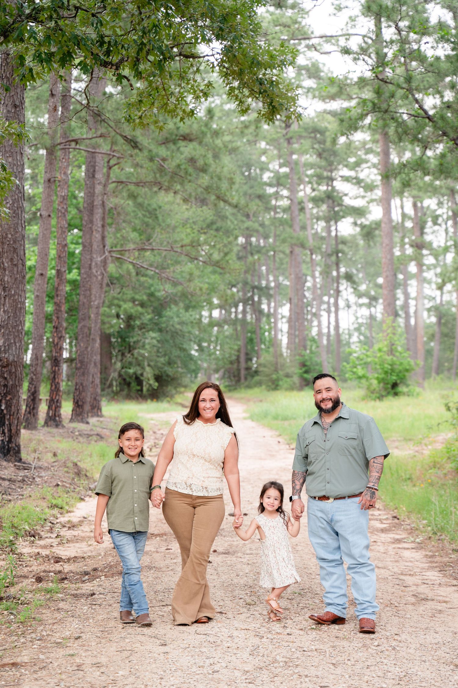 Family of four walking together on a peaceful forest trail.