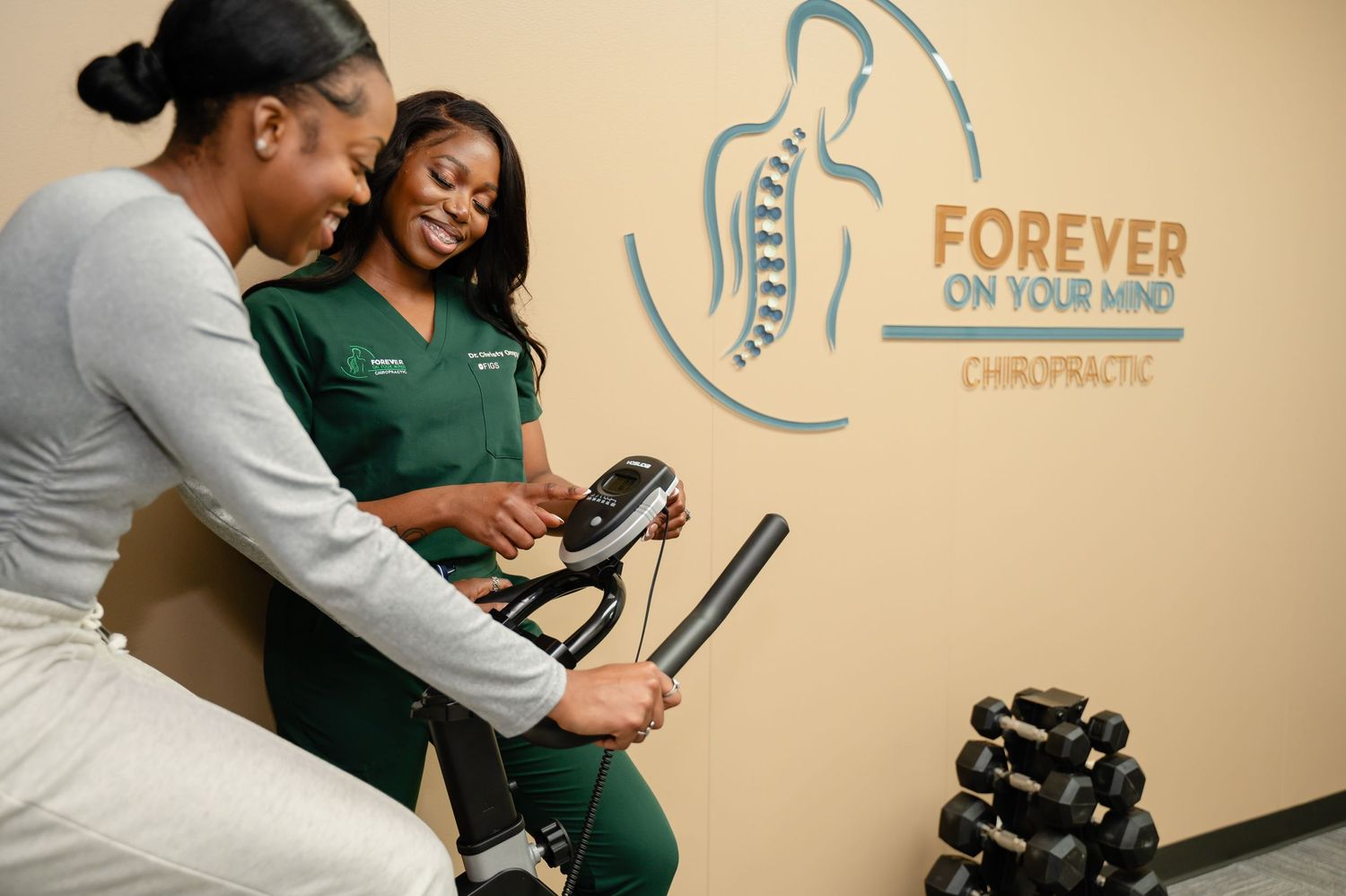 Chiropractic treatment session with Forever On Your Mind logo on wall in background.