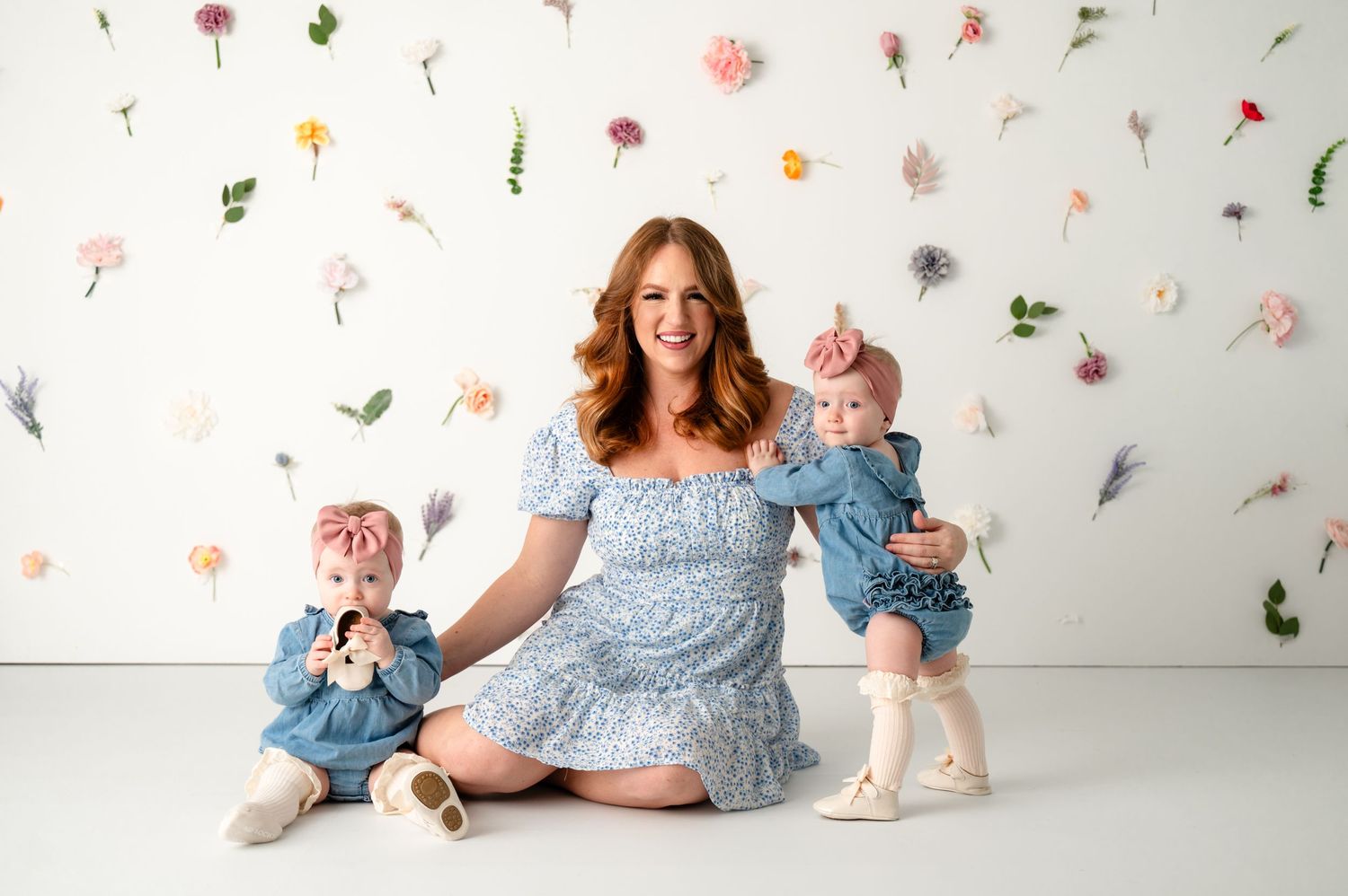 A light blue dress set against a floral backdrop in a whimsical studio setting.