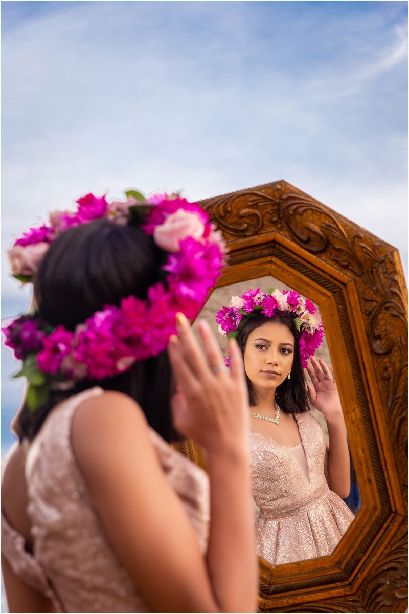 A series of reflective portraits showing a figure wearing a floral crown and lace dress against a wooden headboard.