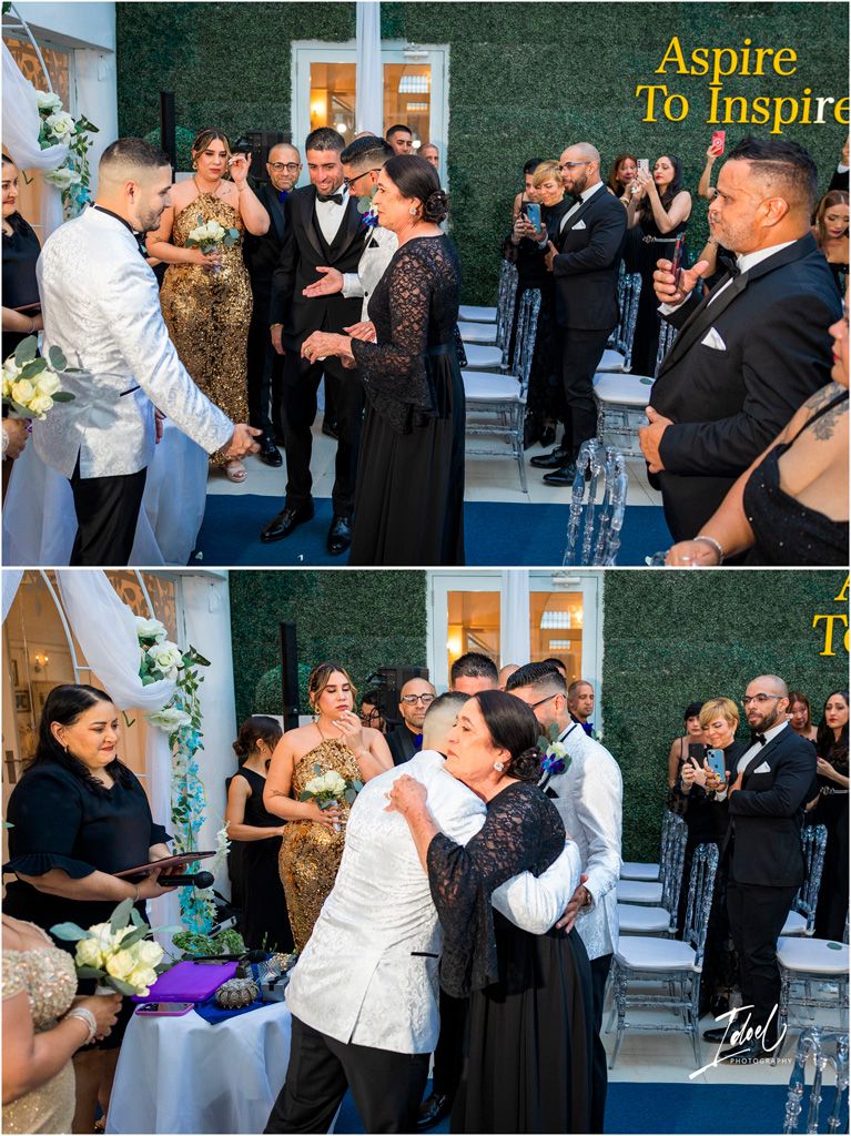 Wedding guests celebrating at a reception venue with a green hedge wall backdrop during an emotional ceremony moment.