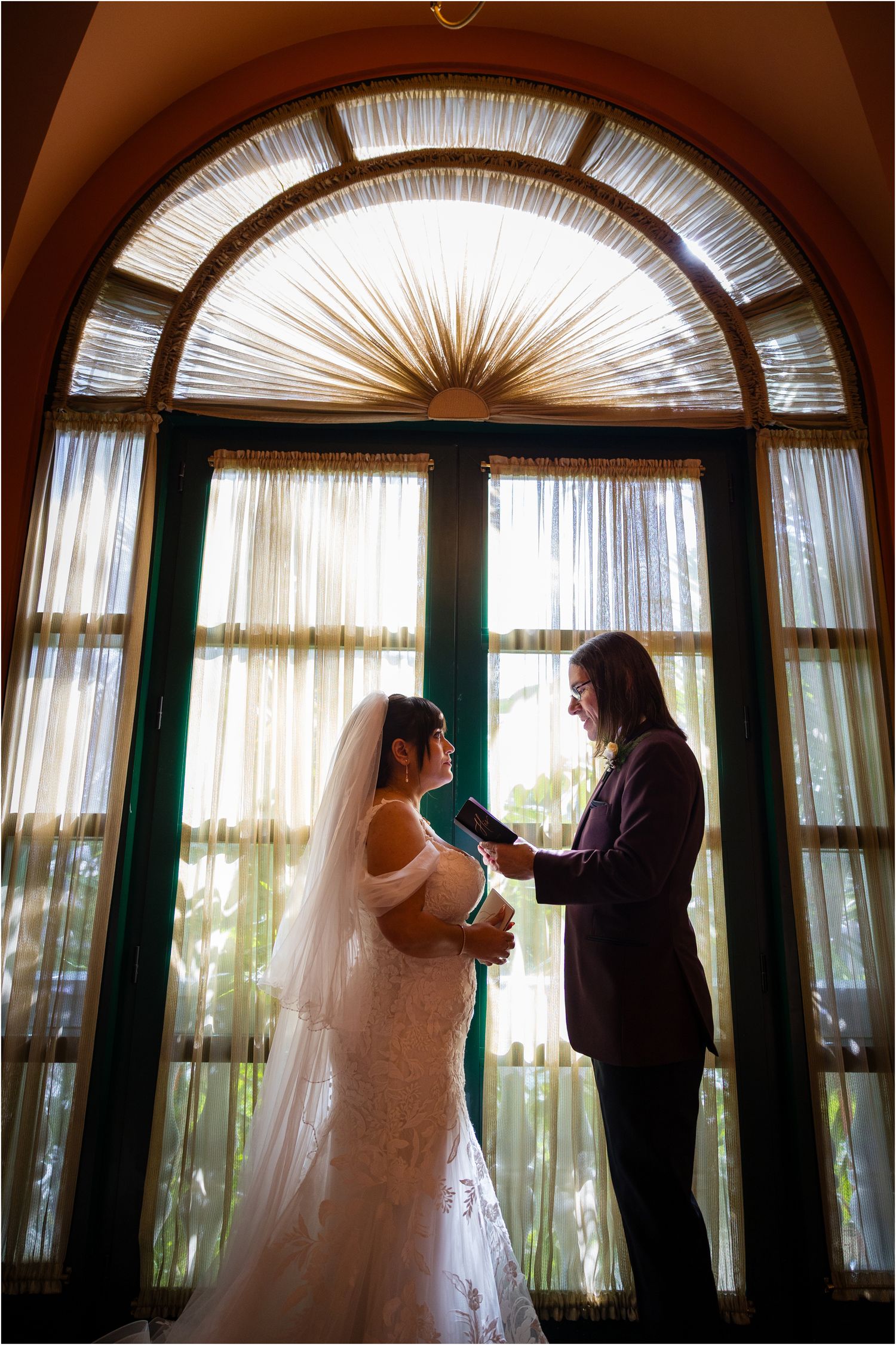 A series of silhouettes showing a couple in a room with dramatic arched windows and natural lighting.