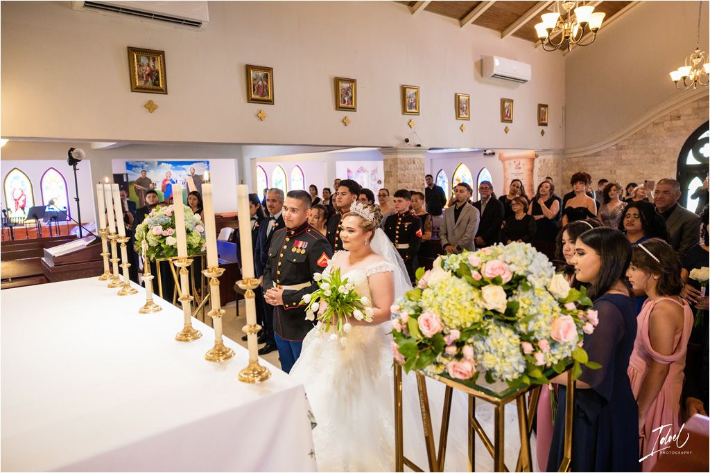 Elegant wedding ceremony in progress with floral decorations and LOVE sign in foreground.