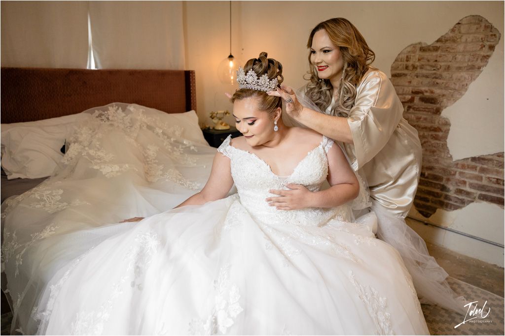Wedding preparation scene with white dress and decorative lighting.