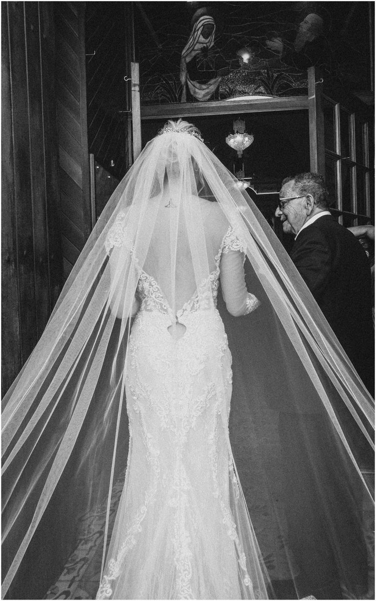 A series of black and white wedding photos showing the back details of a lace bridal gown with flowing veil.