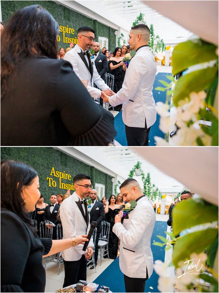 Two people in formal attire sharing an emotional moment during an event while others look on with smiles.