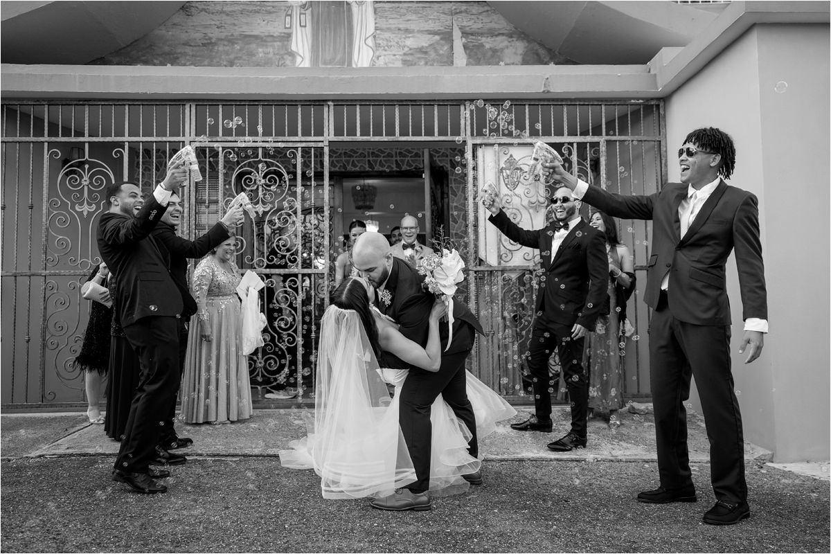 Wedding party performs a choreographed dance routine in formal attire at an outdoor venue.