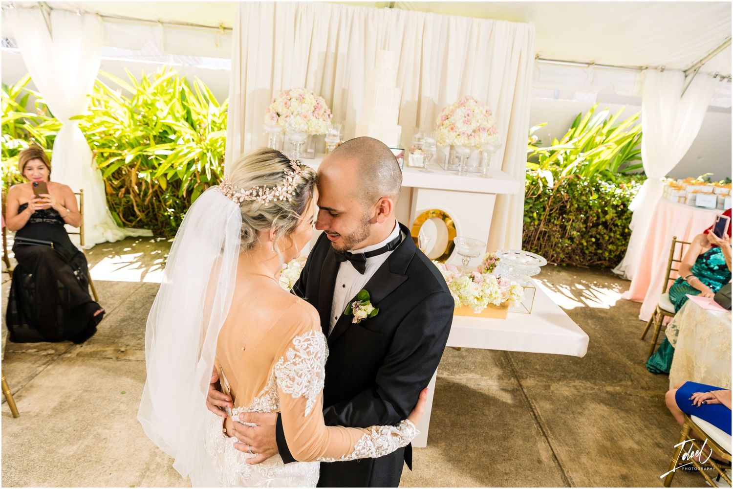 Intimate dance moment shared at elegant outdoor wedding reception with white decor.
