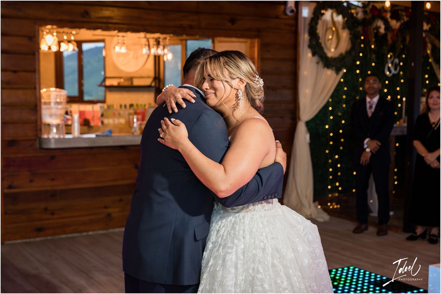 Intimate dance moment in rustic wooden venue with warm lighting and LED floor.