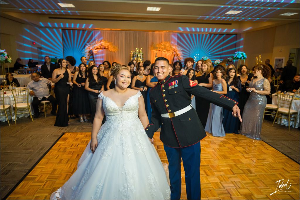 Wedding couple performs their first dance in a ballroom filled with celebrating guests.