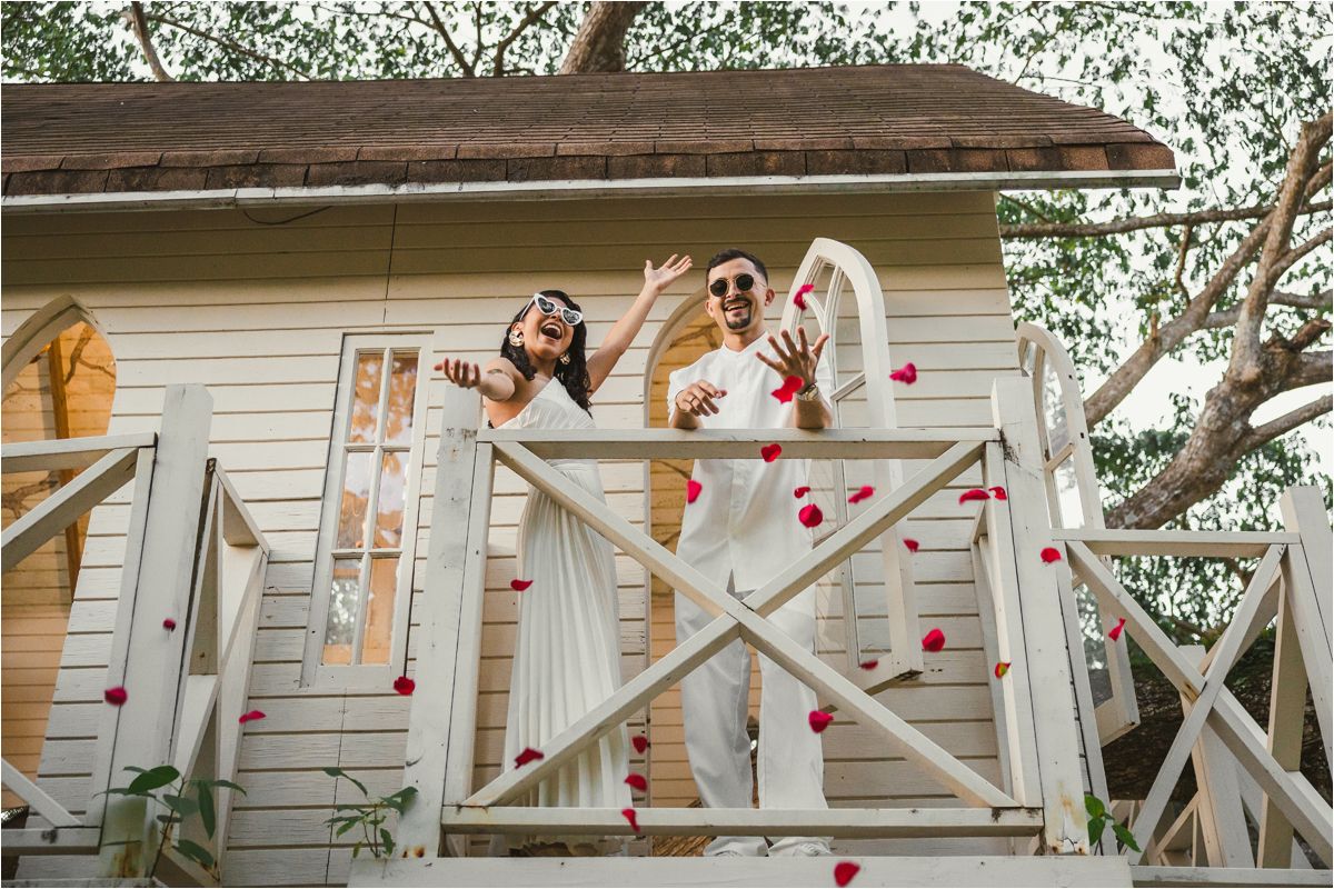A series of white wooden porch railings decorated with red heart ornaments and string lights for Valentine's Day.