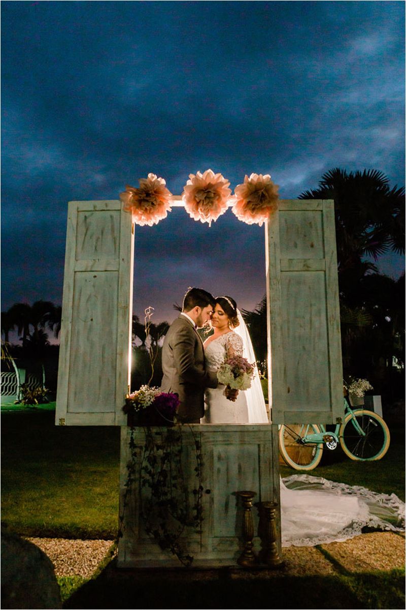 Rustic vintage door wedding arch with floral decorations at sunset creating a romantic backdrop.