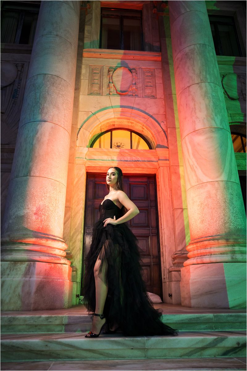 A dramatic fashion photo series showing a figure in a flowing black gown posing on illuminated stone steps with red and green lighting.