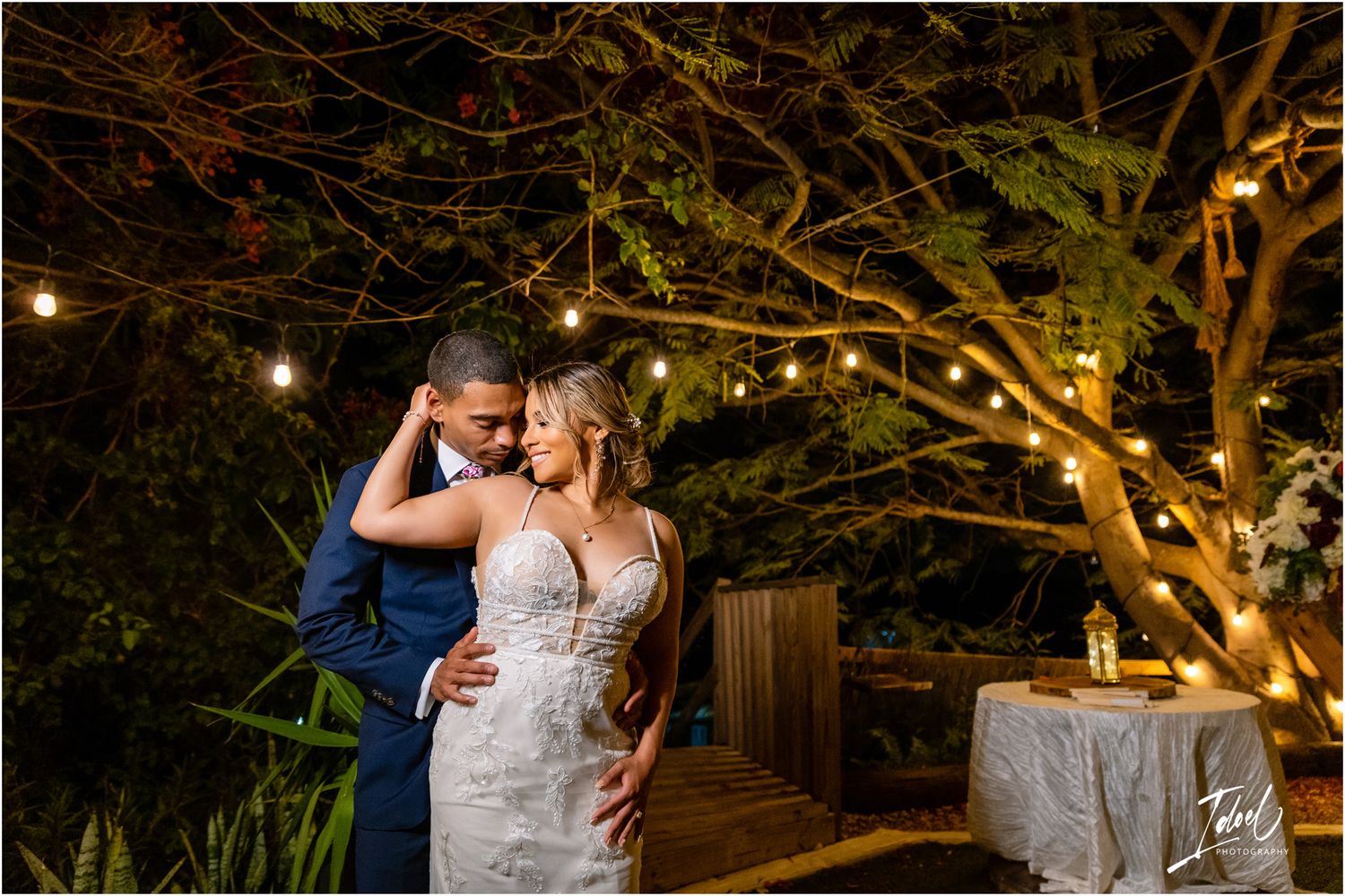 Evening garden romance under string lights and illuminated tree branches.