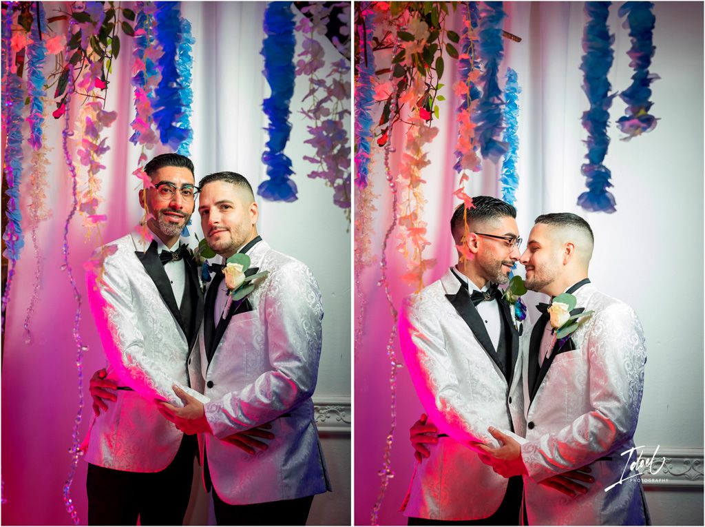 Wedding celebration with floral decorations and colorful lighting featuring romantic couple in matching formal attire.