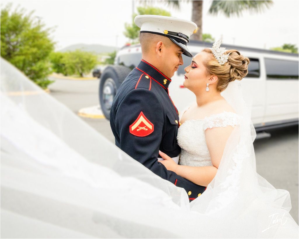 A romantic wedding portrait featuring a couple embracing outdoors in formal attire.