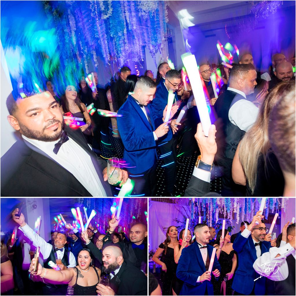 Party crowd dancing and celebrating with glow sticks under dramatic blue lighting at a nightclub event.
