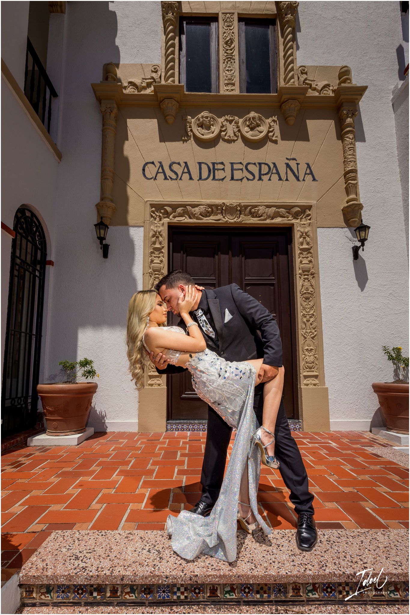 Romantic pose at Casa de España entrance with ornate stone architectural details.