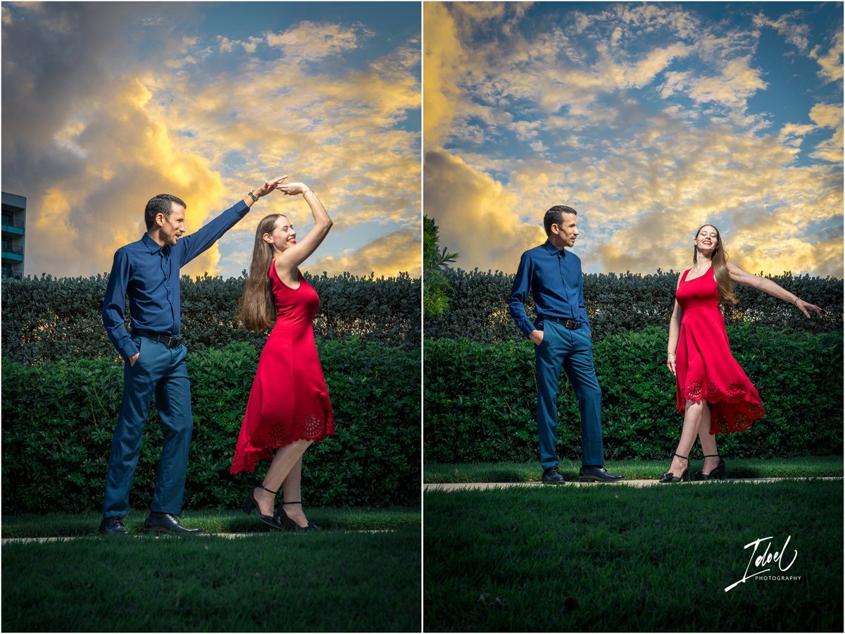Couple dancing outdoors in a garden at sunset, woman in red dress, man in blue shirt, dramatic cloudy sky background.