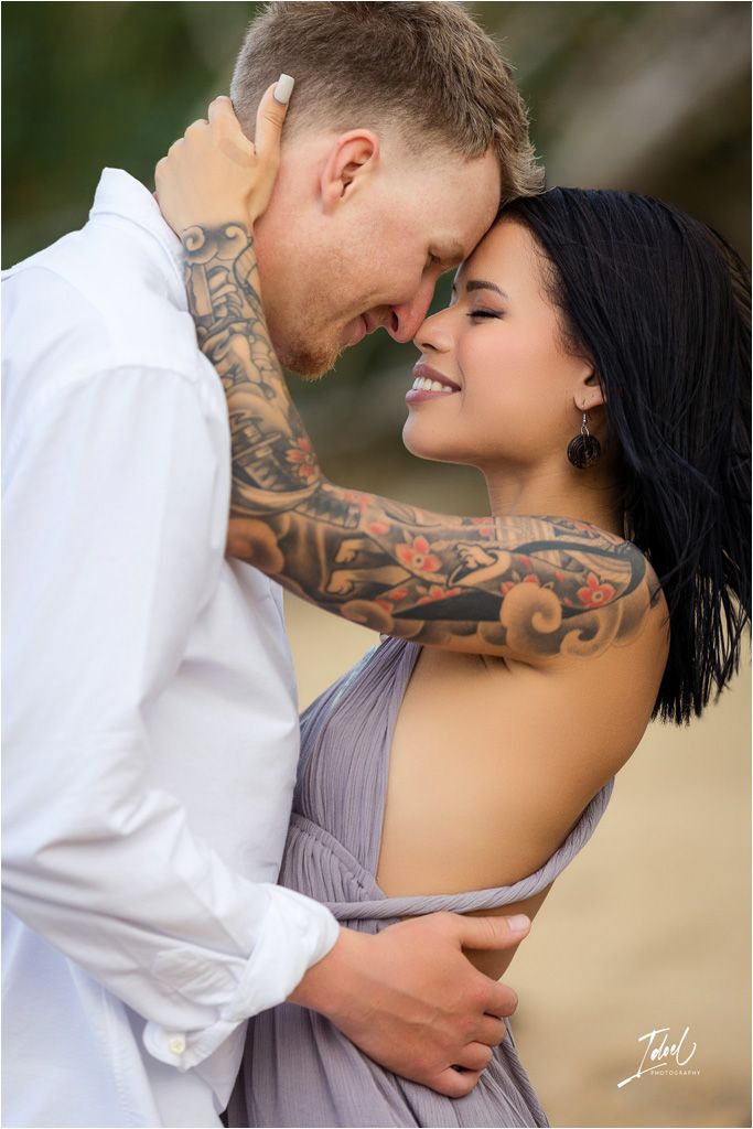 Tender close-up of couple sharing an intimate moment with visible tattoos.