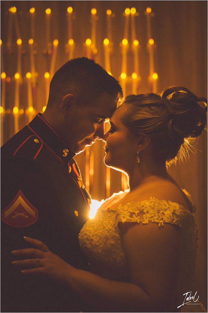 Romantic silhouette of a couple against warm string lights at their wedding reception.