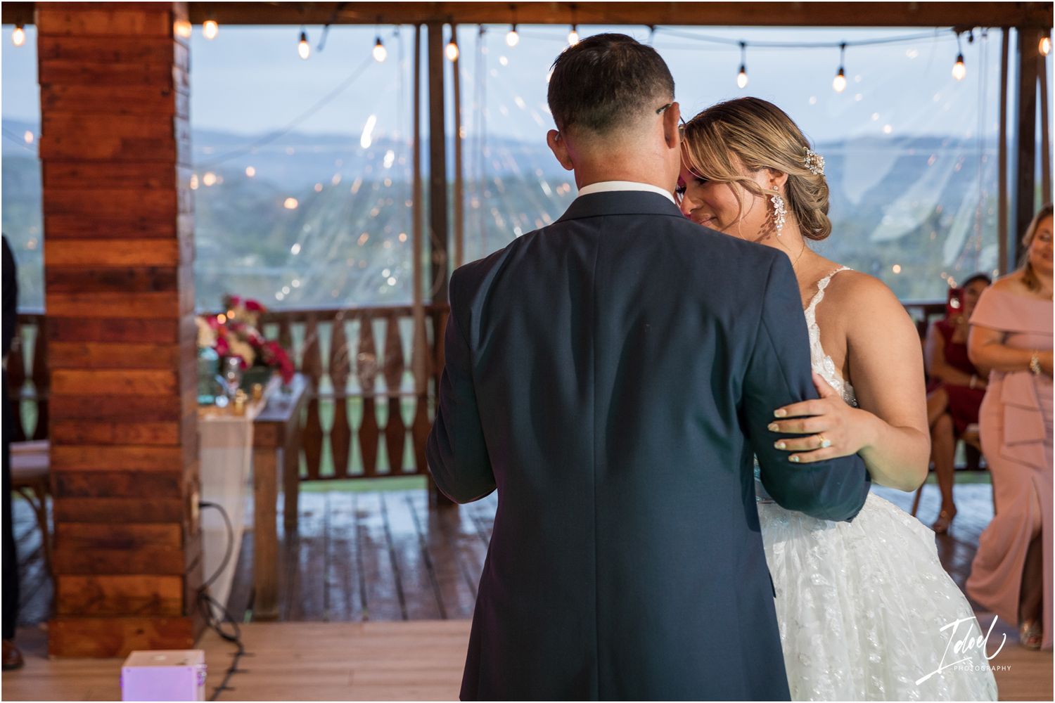Intimate moment in rustic venue with mountain views through large windows.