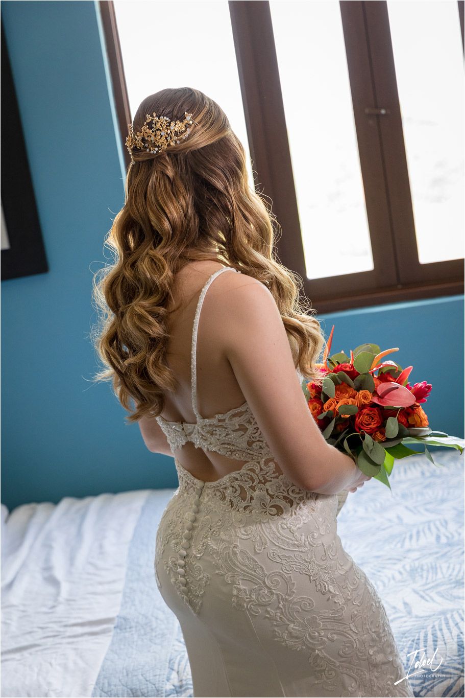 Back view of bridal hairstyle with gold hair accessory and lace dress detail.