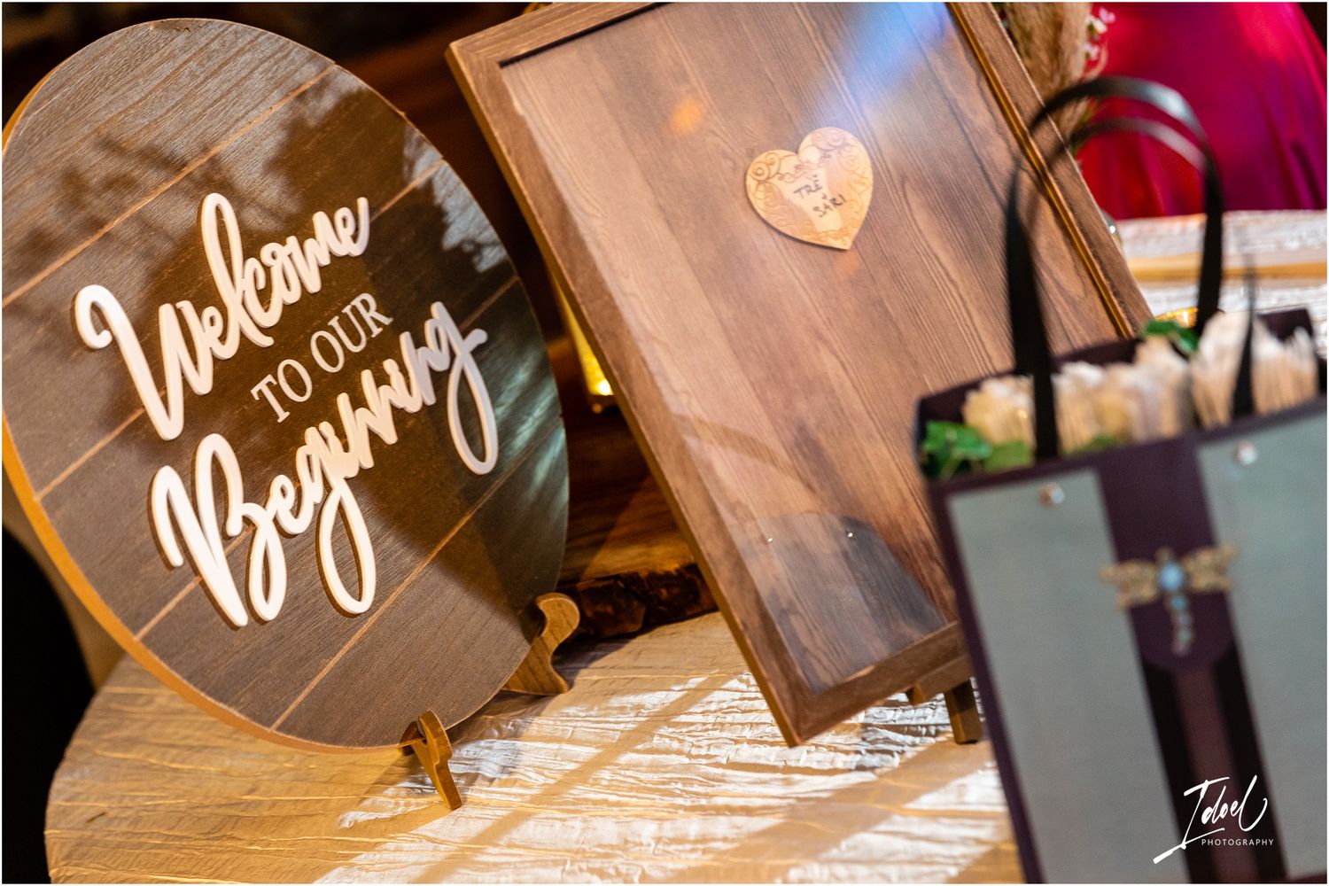 Wooden welcome sign with cursive lettering displayed on an elegant stand.