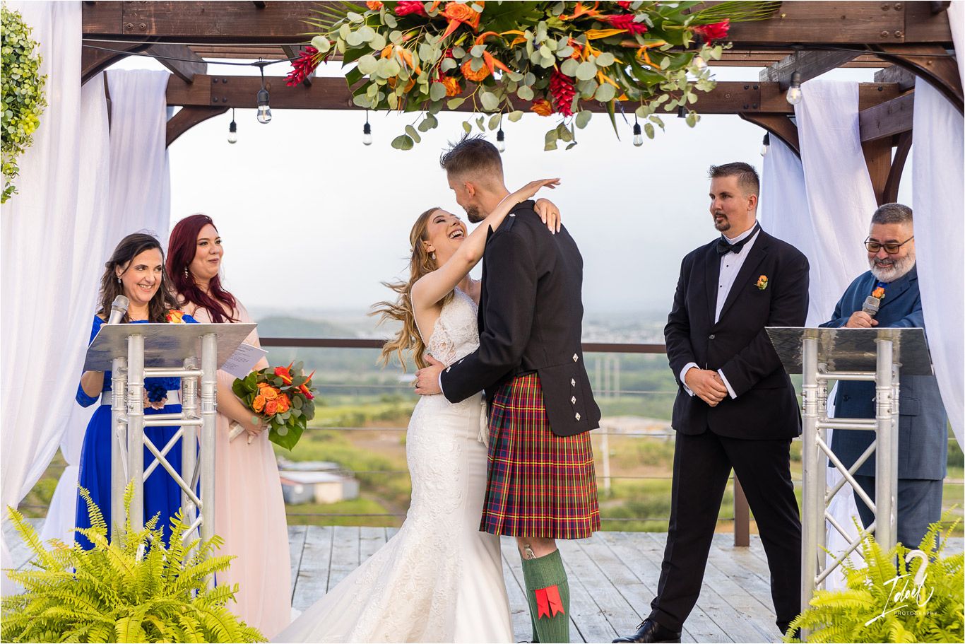 A beautiful outdoor wedding ceremony with traditional Scottish attire and elegant decorations.