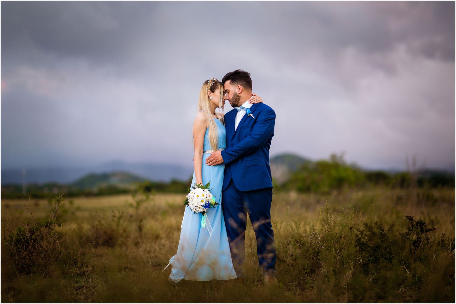 A couple share an intimate moment in a misty field during golden hour.