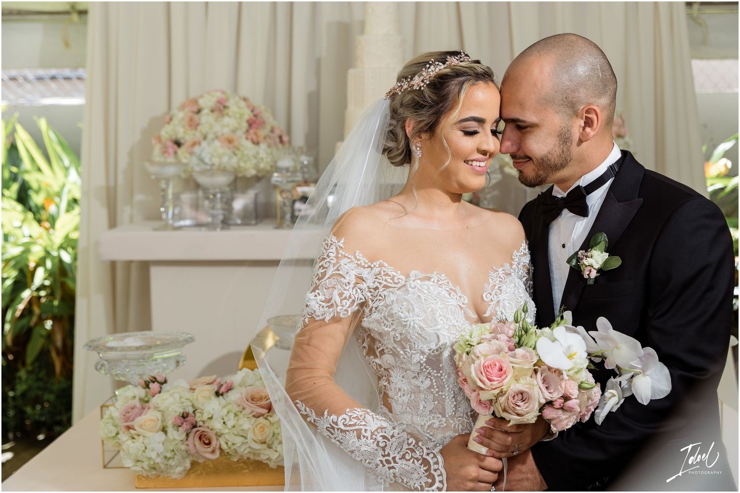 A tender moment captured between newlyweds with soft pink floral bouquet.