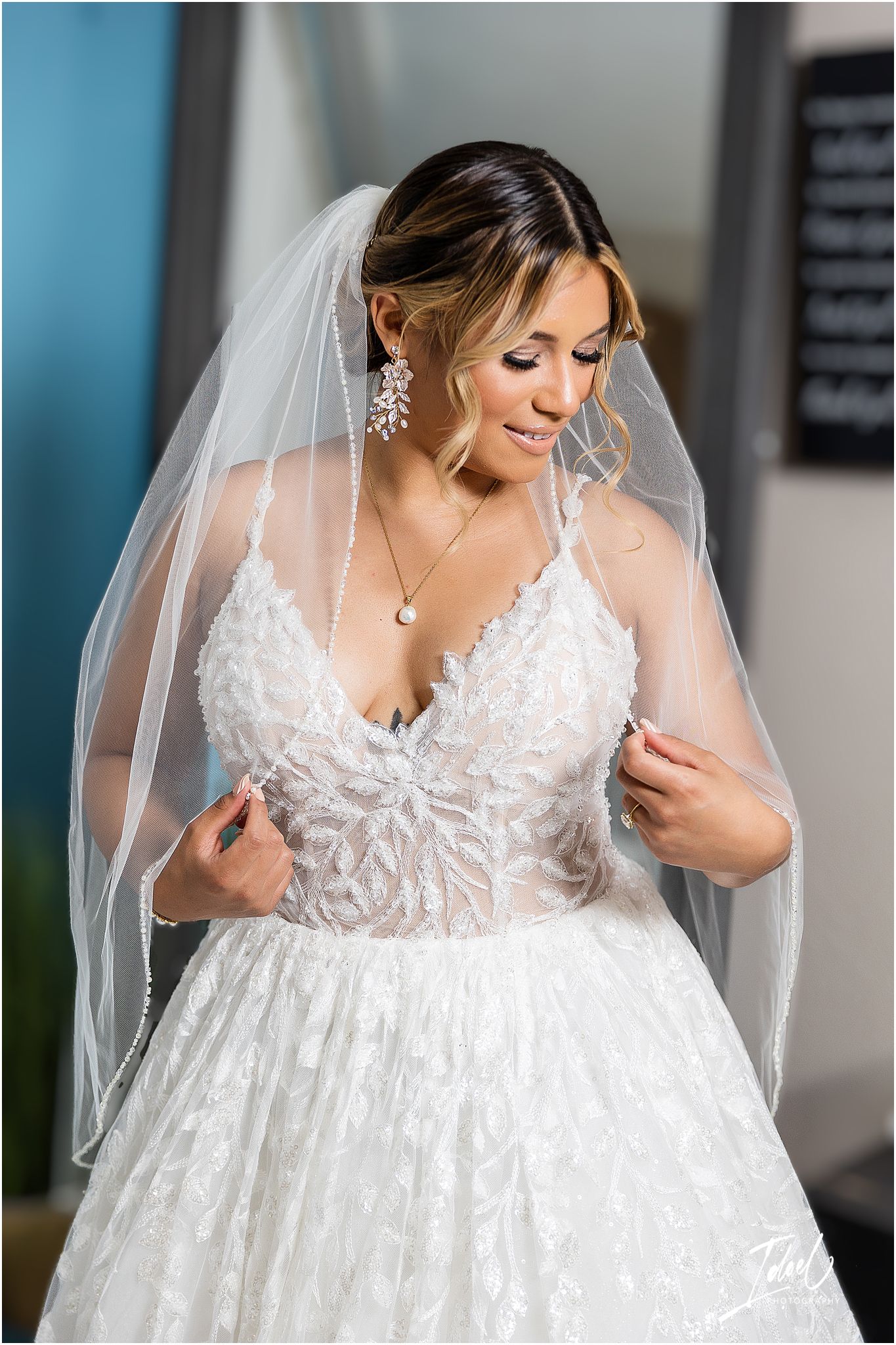 Side view of detailed lace wedding gown with flowing veil and delicate embellishments.