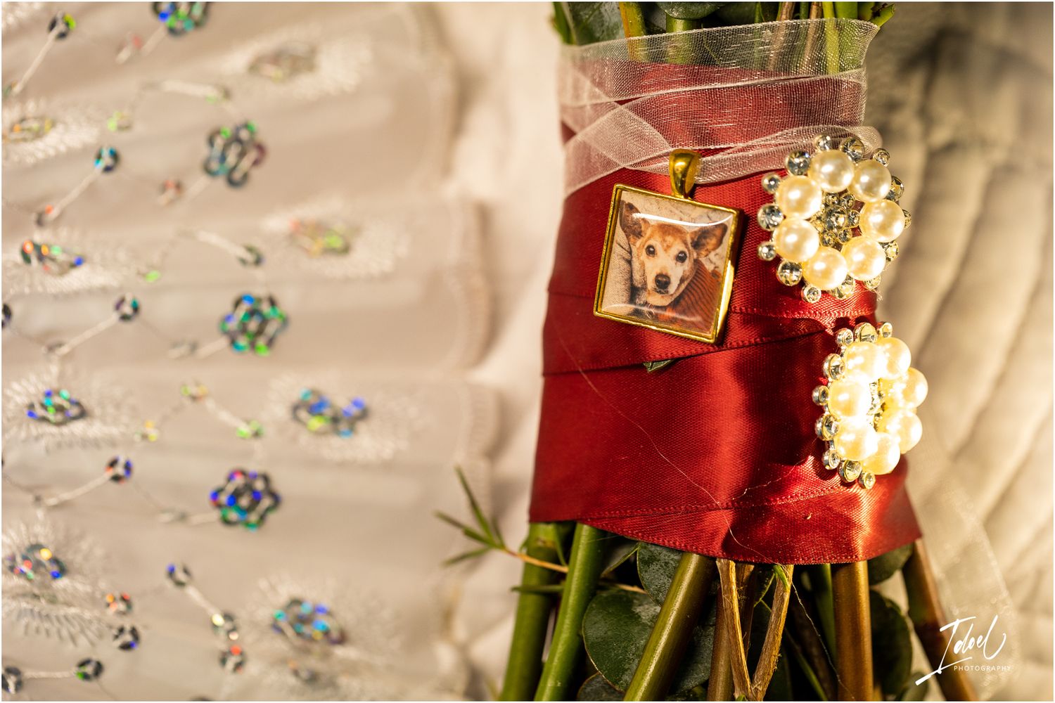 Close-up of wedding jewelry and decorative details on red and white fabric with crystal embellishments.