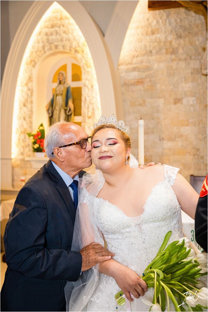 Tender moment captured during a wedding with white floral bouquet and sparkling tiara.