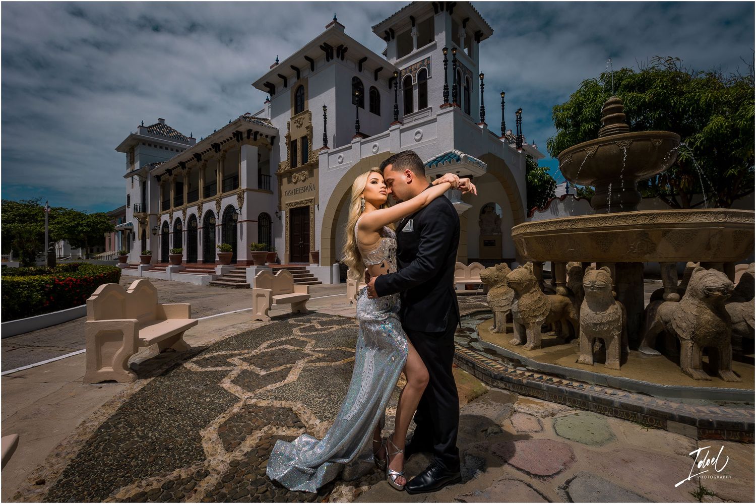 Elegant photo session in front of historic Spanish colonial architecture with stone fountain.