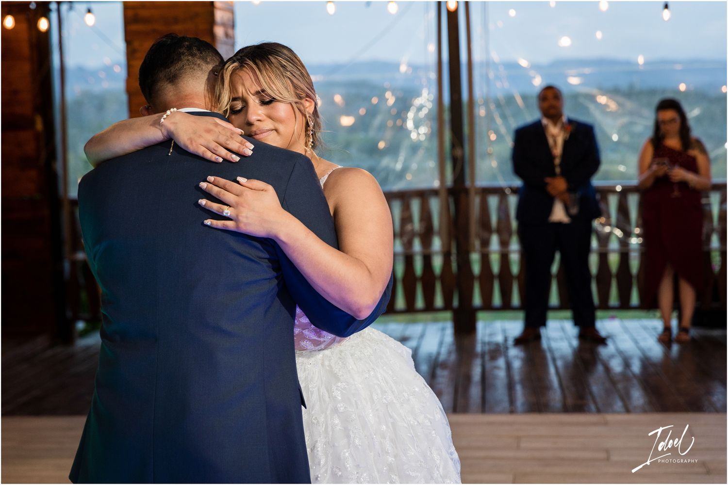 A romantic embrace during a first dance at a rustic mountain wedding venue with scenic views.