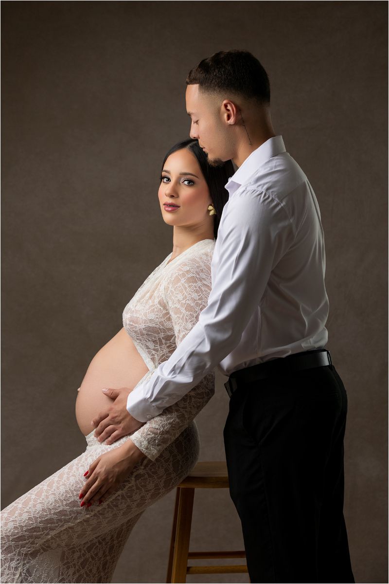 A series of intimate maternity photos showing a pregnant woman in white lace being embraced tenderly from behind.