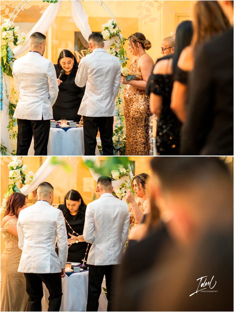 Wedding ceremony attendees gather around an elegantly decorated table during what appears to be a signing ceremony.