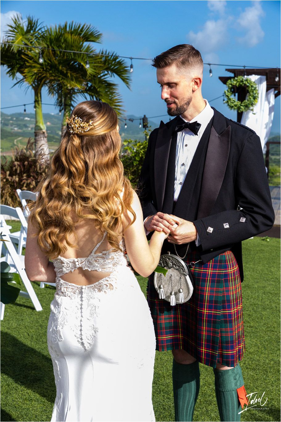 Traditional Scottish kilt and modern wedding dress during outdoor ceremony exchange.